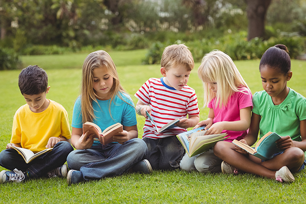 Children reading outdoors