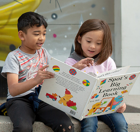 Two children reading a book together