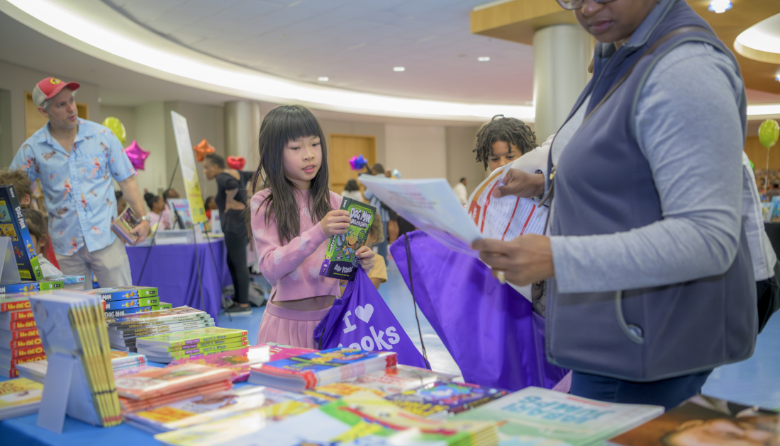child putting book in bag