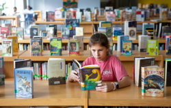 Girl in library reading book