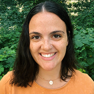 Karly O'Brien smiles at the camera while outdoors. She is the Content Developer for Reading is Fundamental.