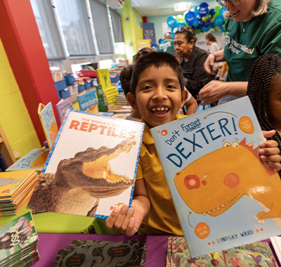 Happy kid holding up two books