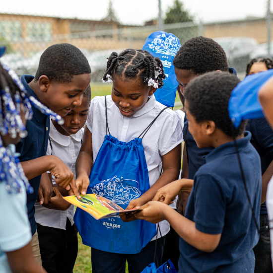 Kids huddled outside together reading books