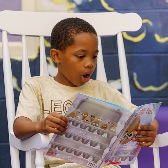 A kid reading a book and looking engaged