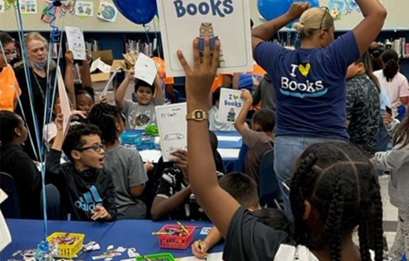 Girl holding an I heart books book