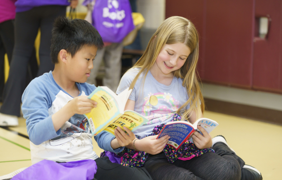 A boy and a girl reading together