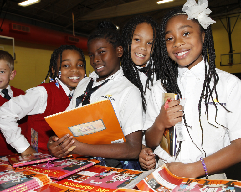 Older students smiling with books